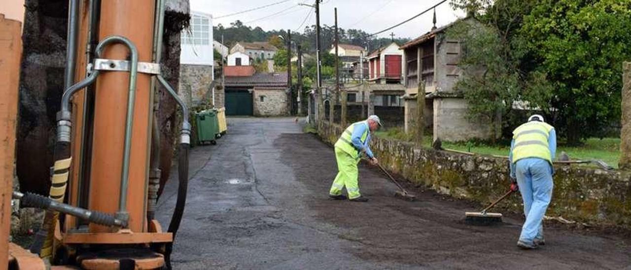 Dos operarios durante la reparación de uno de los viales de Valga. // FdV