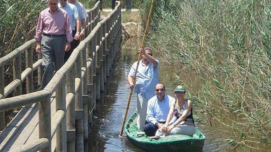 El alcalde y Charo Quesada, en la barca, y en el puente, Manuel Serrano, ayer en El Hondo.