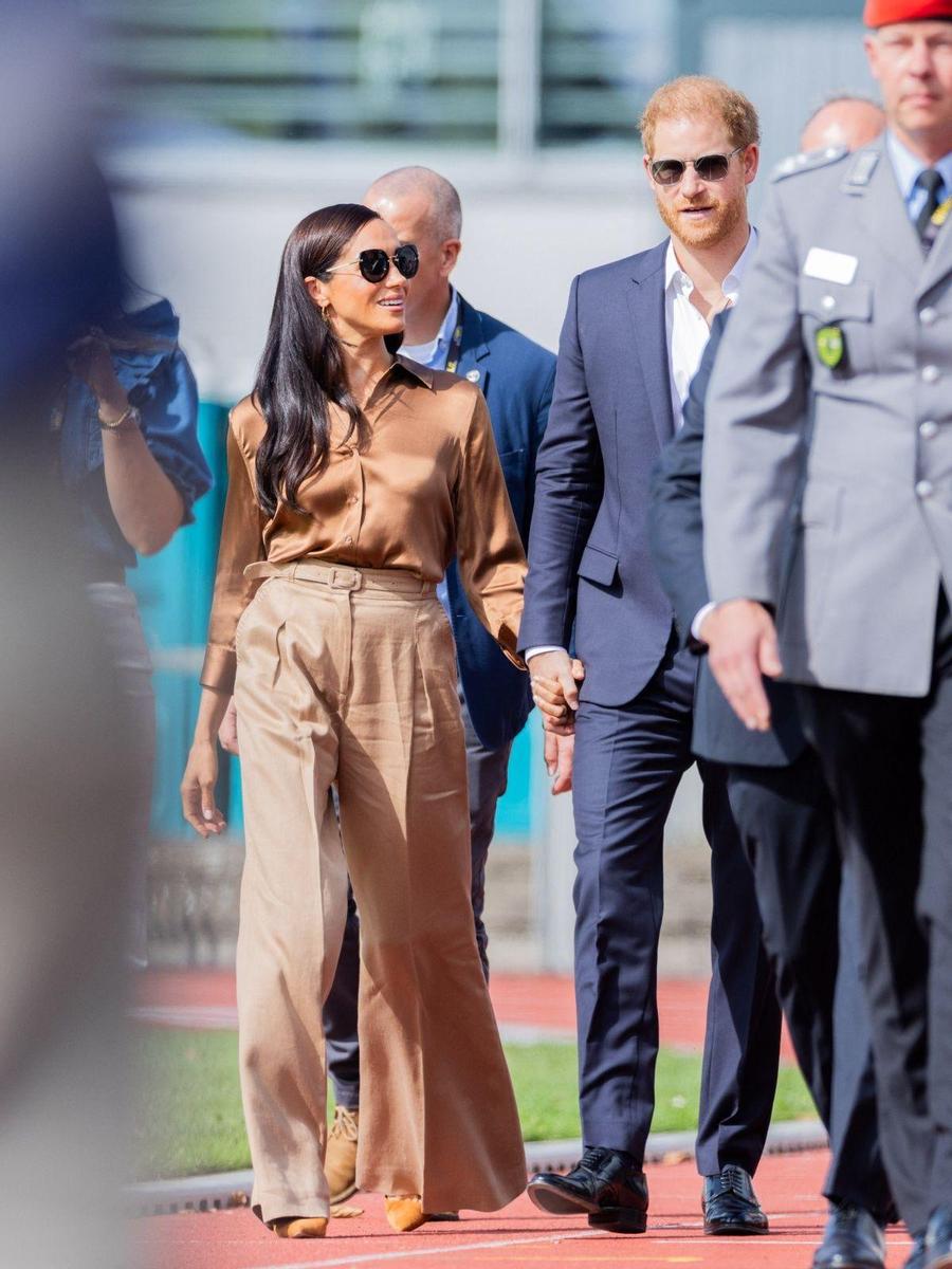 Meghan Markle con blusa marrón y pantalón ancho