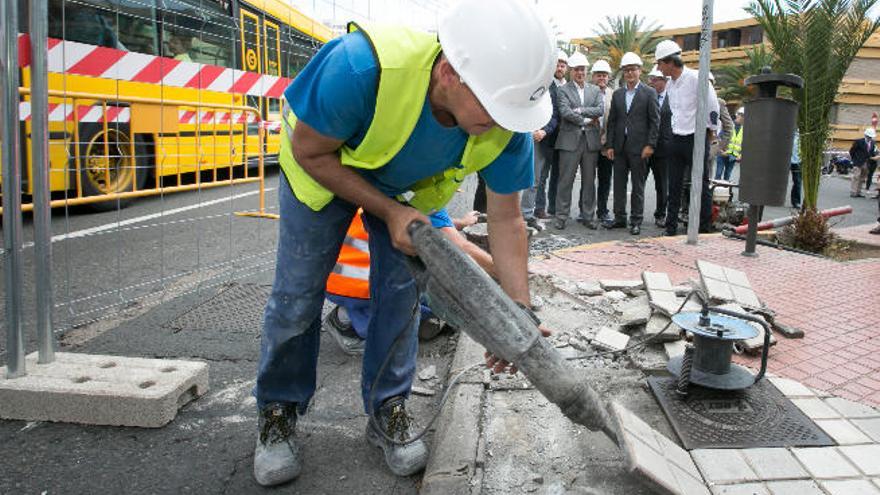 Un operario retira una baldosa durante la inauguración de las obras.