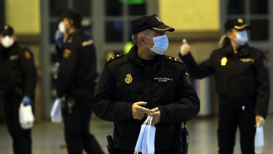 Policías entregan mascarillas en el metro de Valencia.