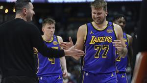 Los Angeles Lakers head coach JJ Redick, left, congratulates guard Luka Doncic as he heads to the bench late in the second half of an NBA basketball game against the Denver Nuggets, Saturday, Feb. 22, 2025, in Denver. (AP Photo/David Zalubowski)