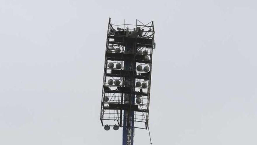 Un bombero y un policía local observan ayer la torre de luz con el cabezal caído.