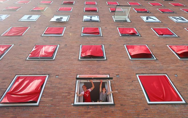 Estudiantes exhiben la bandera danesa y un mensaje de apoyo a Christian Eriksen en su edificio (Copenhague, Dinamarca)