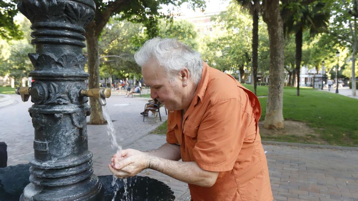 Un hombre se refresca del intenso calor en una fuente pública. | ANDREEA VORNICU