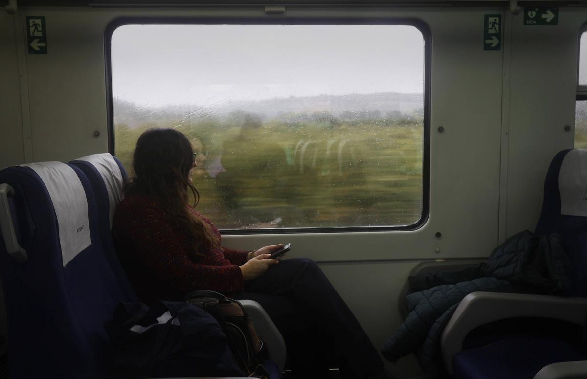 Una xica mira per la finestra d'un tren a València