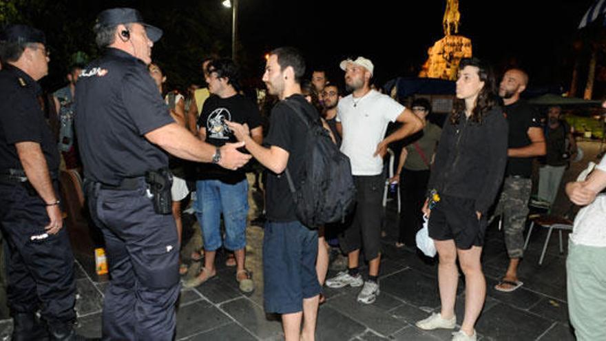 Agentes de la Policía Nacional se dirigen a los ´indignados´ para reclamarles que desalojen la plaza de España de Palma.