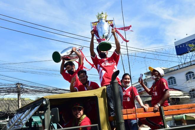 Los fanáticos tailandeses del Liverpool Football Club celebran la victoria de la Premier League inglesa con réplicas de trofeos durante un desfile en la provincia de Narathiwat, en el sur de Tailandia.