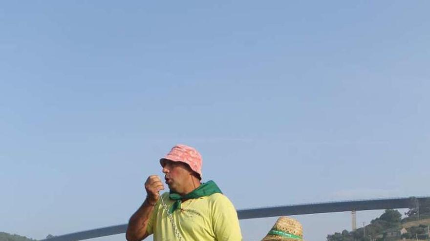 José Manuel Peláez y Joel García, de la comisión de fiestas, defienden el juego de la suelta del pato, anteayer, en la playa de Cueva.