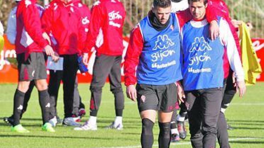 Nacho Novo, abrazando a De las Cuevas en el entrenamiento de ayer.