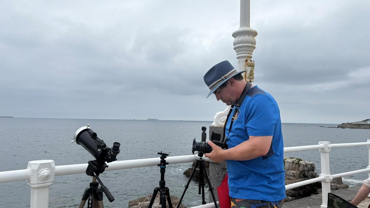 Michaël Lefel haciendo una foto con su cámara analógica a las vistas de Gijón desde el muro de la playa de San Lorenzo