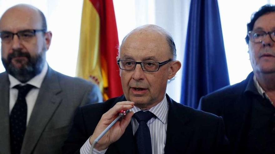 El ministro Cristóbal Montoro, entre Miguel Borra (i., CSIF), y Julio Lacuerda (d., CC OO). // S. Barrenechea