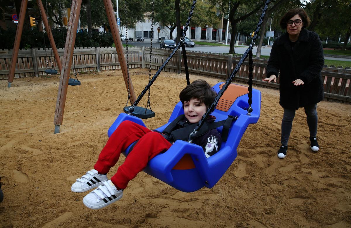 Bruno sonríe mientras su madre le columpia en el parque de la Vila Olímpica.