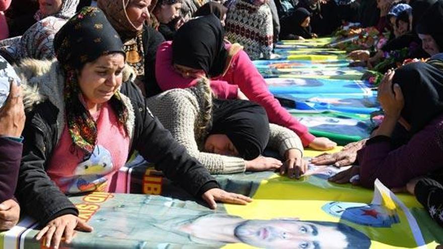 Mujeres kurdas lloran la muerte de combatientes.