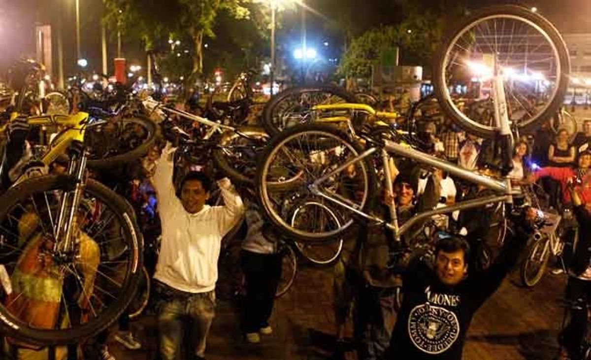 Diversos ciclistes aixequen les seves bicicletes durant una protesta per promoure l’ús d’aquest vehicle a Lima (Perú).