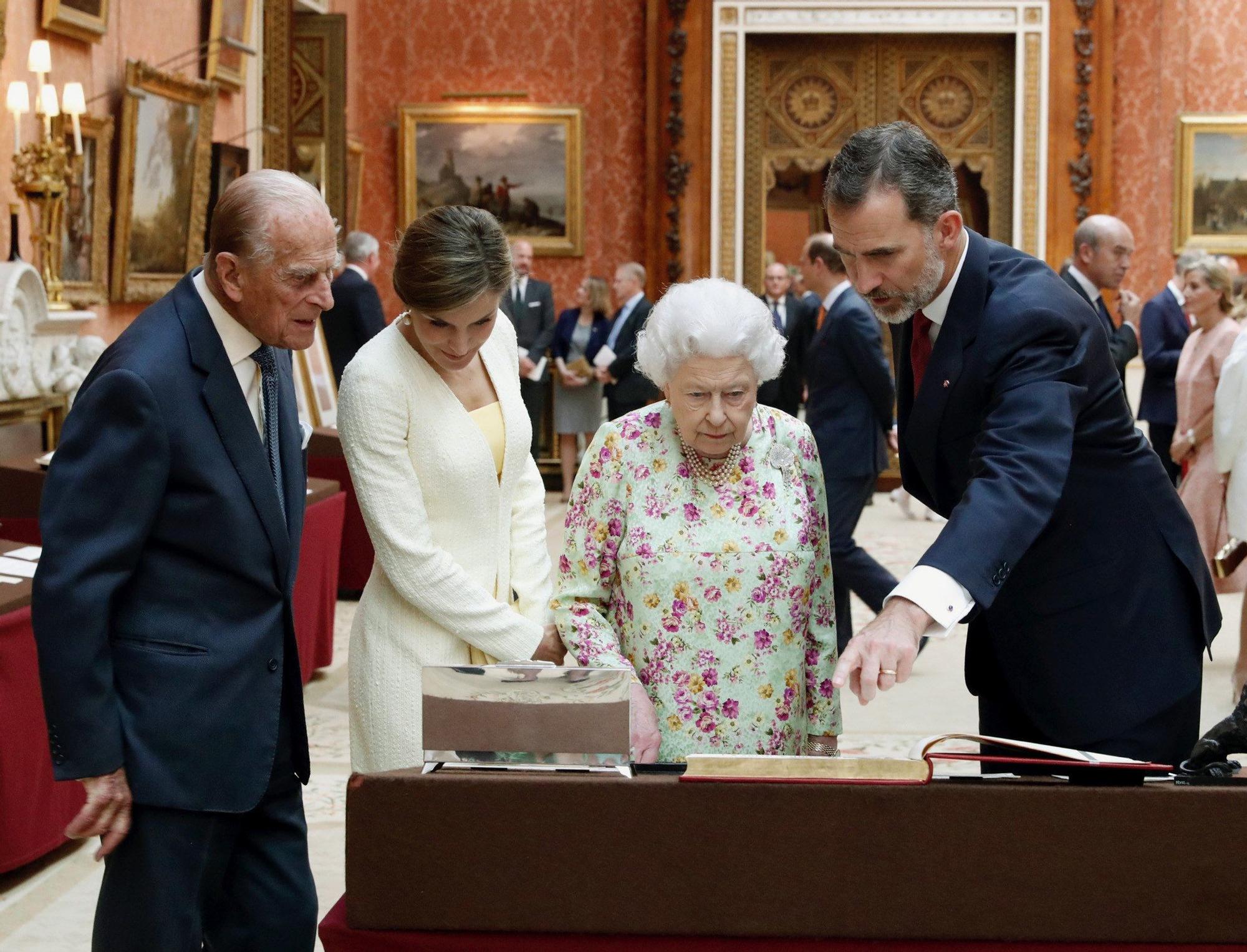 Los Reyes, Felipe VI (d) y Letizia (2i), junto a la reina Isabel II (2d), y su marido, el duque de Edimburgo (i), durante la visita a una exposición de objetivos españoles pertenecientes a la colección Real en la Picture Gallery.