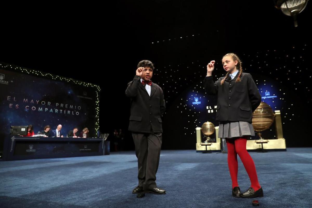 Josué Ariel Guamán y Aroa Patricio muestran el número 06914, dotado con 500.000 euros por serie, 50.000 euros al décimo, el tercer premio del sorteo extraordinario de Lotería de Navidad, el más esperado del año, que repartirá hoy 2.380 millones de euros en premios (70 más que en 2016) a través de los 15 millones de premios que llenarán de alegría a miles de afortunados cuando los niños de San Ildefonso canten el número que llevan en sus bolsillos. EFE