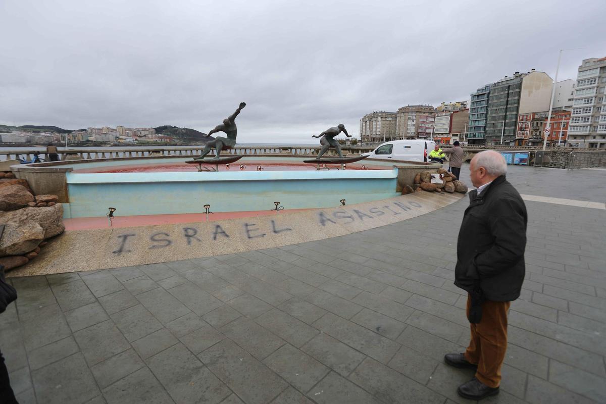 La fuente de los surfistas, con el agua teñida de rojo y una pintada contra Israel La fuente de los surfistas, con el agua teñida de rojo y una pintada contra Israel