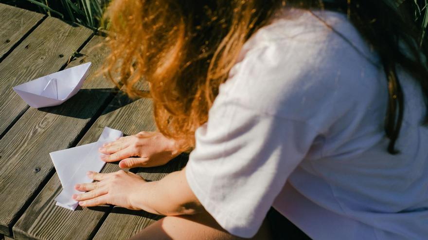 Una niña haciendo figuras de origami. | |  PEXELS / SHVETS