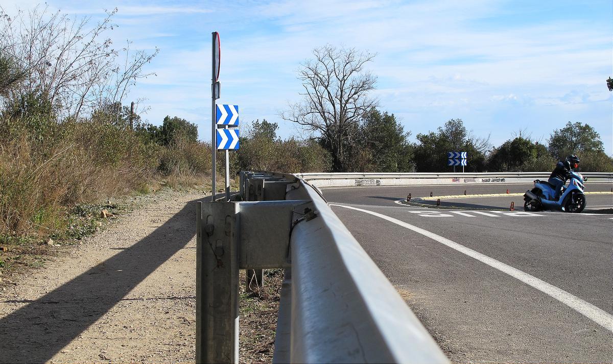 Una moto toma la curva de la 'paella' de la Arrabassada. A la izquierda, el pequeño camino que lleva hasta la conexión del paseo de las Aigües que justo aquí vuelve a retomarse