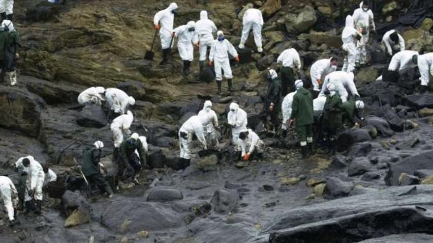 Voluntarios limpian las costas de Muxía tras la marea negra del &#039;Prestige&#039;, en noviembre de 2002. / lavandeira jr