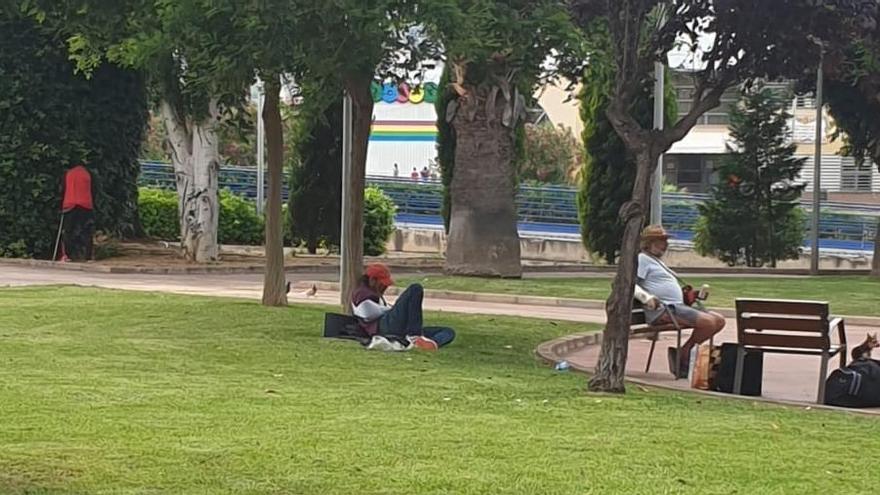 Varias personas sin hogar en el parque Corona d&#039;Aragó esta semana. Uno de ellos hace sus necesidades entre los árboles en una zona infantil