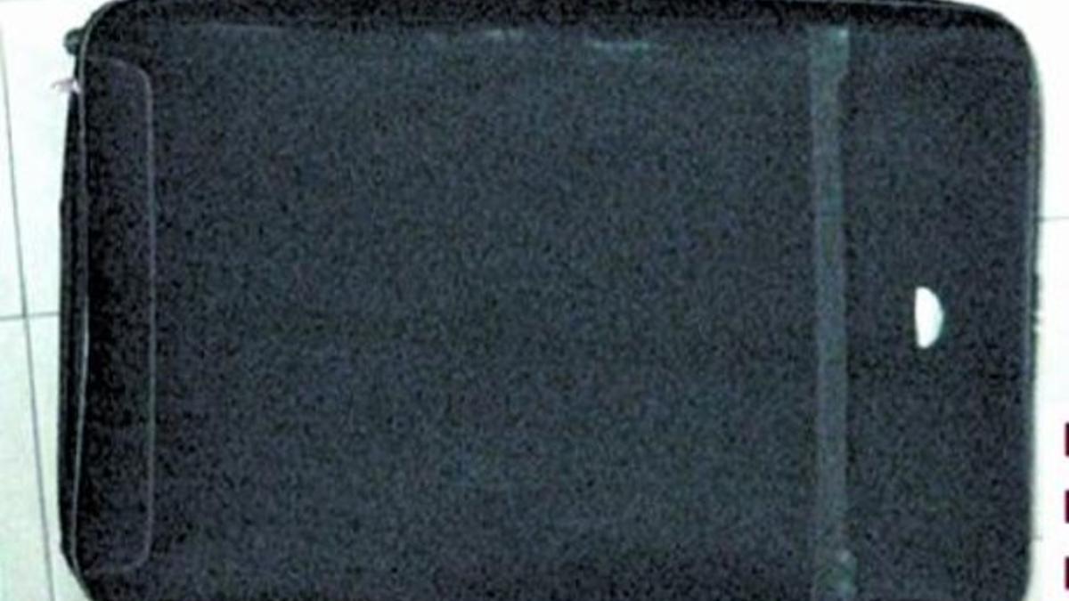 DE PELÍCULA 3 Arriba, fotograma de 'El robo más grande jamás contado', filme en el que Javier Aller (segundo por la izquierda) interpreta a un ladrón que usa el mismo método. Junto a estas líneas, la maleta en la que los Mossos hallaron al contorsion