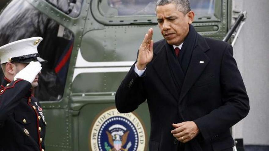 Obama saluda a un militar a su llegada a la Casa Blanca procedente de Hawai.  // Reuters