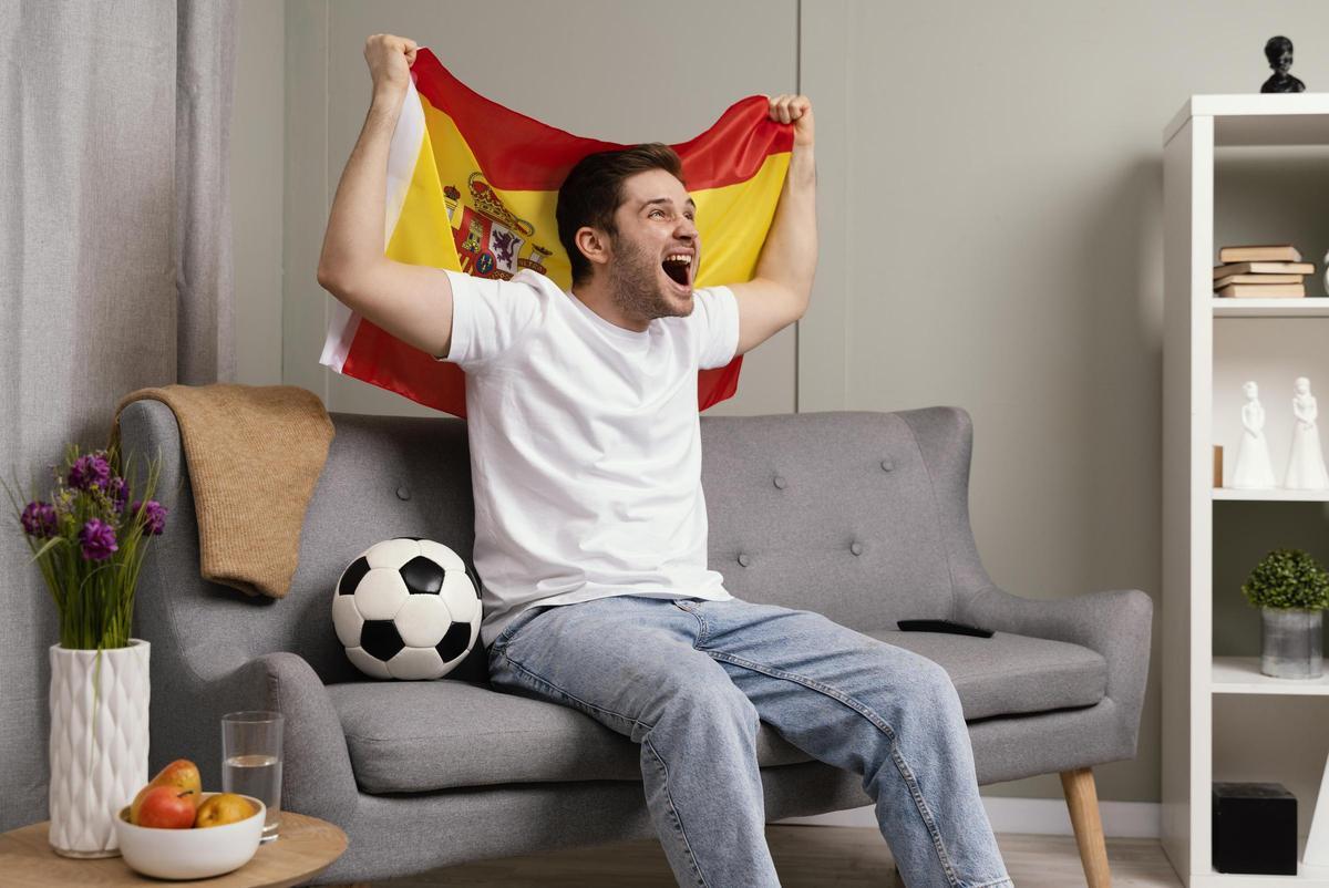 Un hombre celebrando el triunfo de la Selección española en el sofá de su hogar
