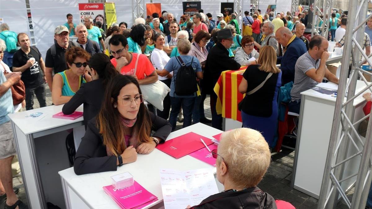 Diversas personas solicitando información en el espacio 'Eines de País', ubicado en el Pla de Palau.