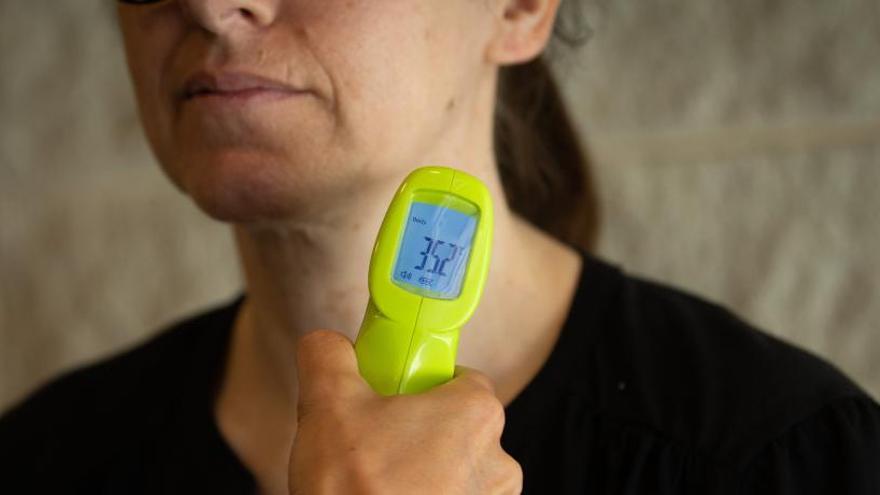 A una dona li prenen la temperatura per saber si hi ha possibilitat de coronavirus