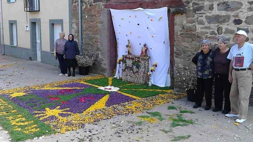 Vecinos de Figueruela de Abajo junto al altar con la alfombra de flores elaborada por el pueblo para celebrar la fiesta del Corpus.