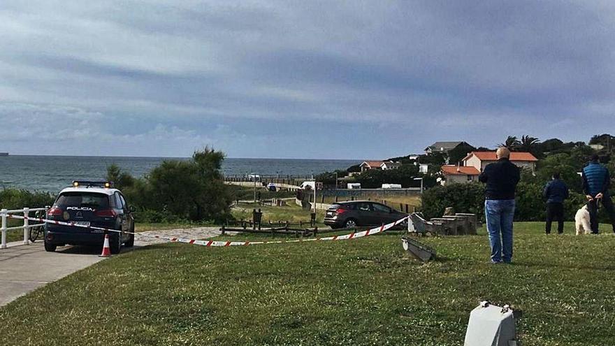 Paseantes en la zona del Rinconín, en Gijón, acordonada ayer por la Policía Nacional.