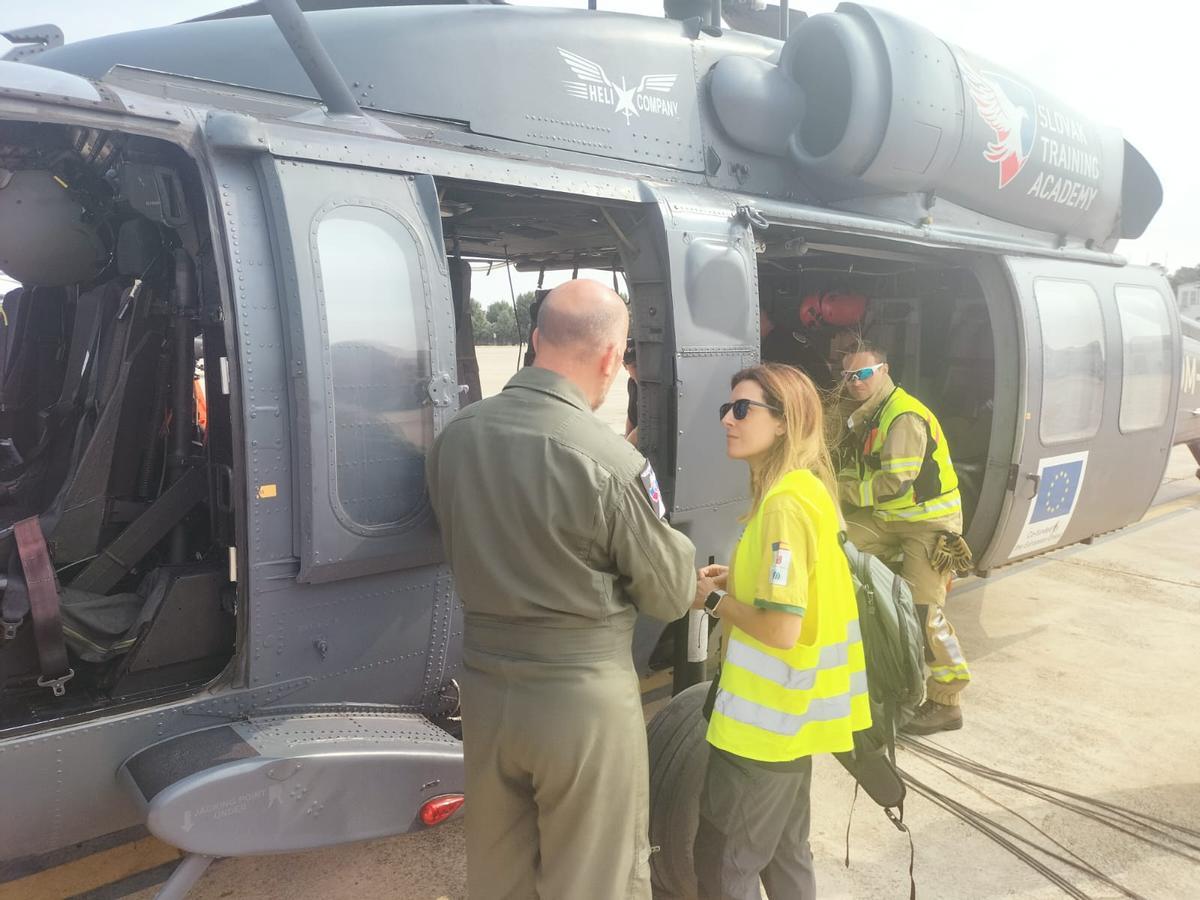 Los dos técnicos se suben al helicóptero para emprender el viaje