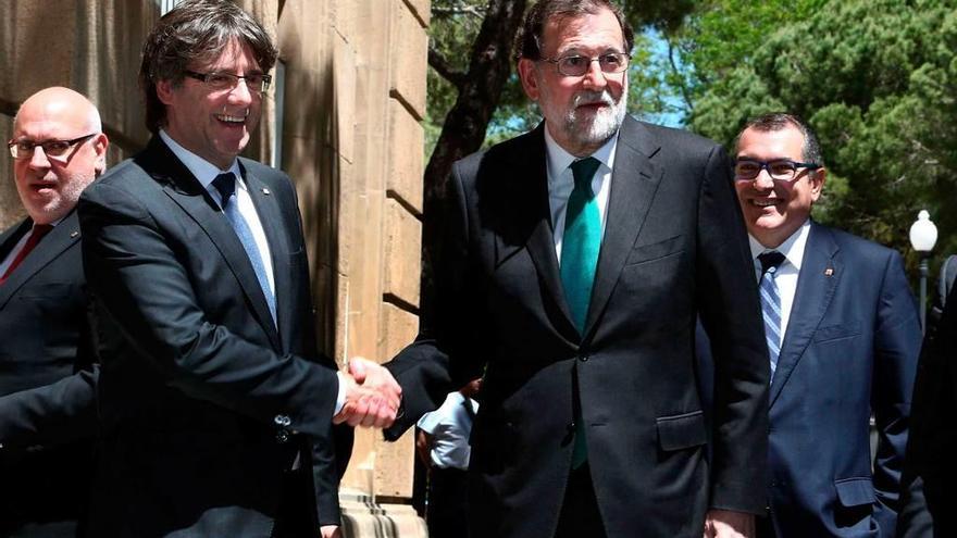 Puigdemont y Rajoy se saludan antes de inaugurar el renovado Salón del Automóvil de Barcelona.