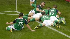 Los jugadores de Irlanda del Norte celebran el primer gol en el mojadísimo terreno de juego de Lyón