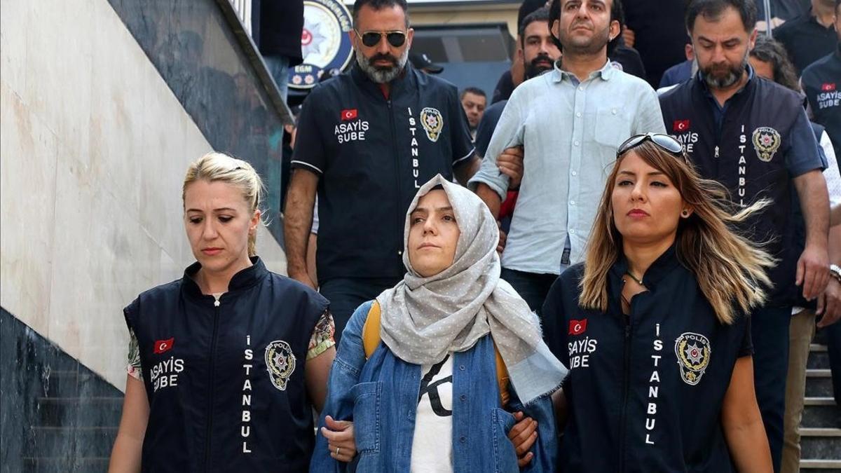 La policía escolta a una periodista detenida ante el juez en Estambul.
