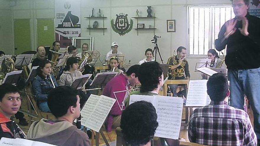 David Moen dirige a la Banda de Música de Candás en un ensayo.