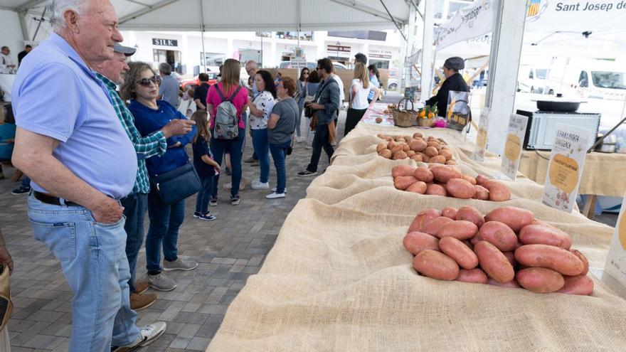 Unos asistentes contemplan el expositor con las variedades de patata roja ibicenca.