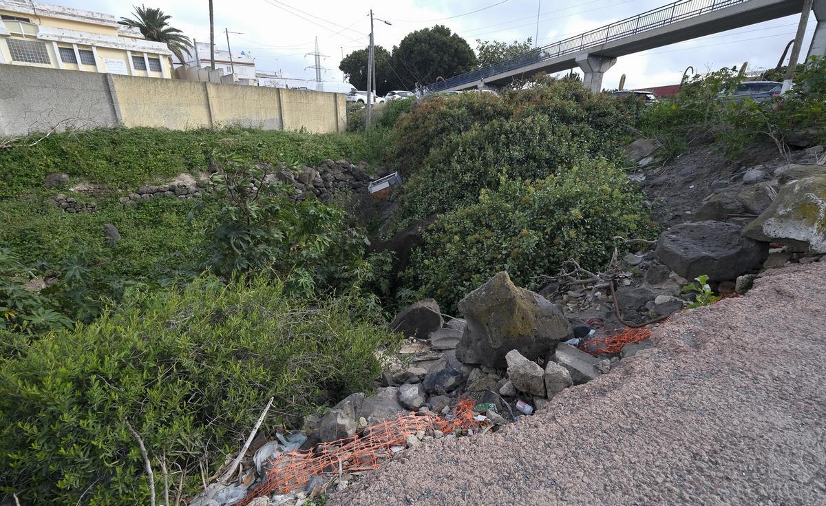 Estado del barranco junto a la vía, sin vallas de protección y con acumulación de basura.