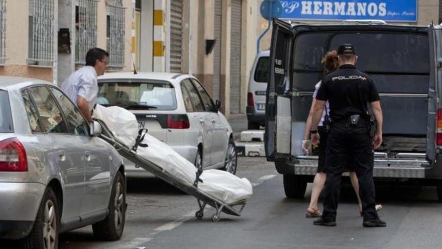 Empleados del tanatorio retiran el cadáver de la joven de 28 años asesinada el pasado lunes en Alicante.