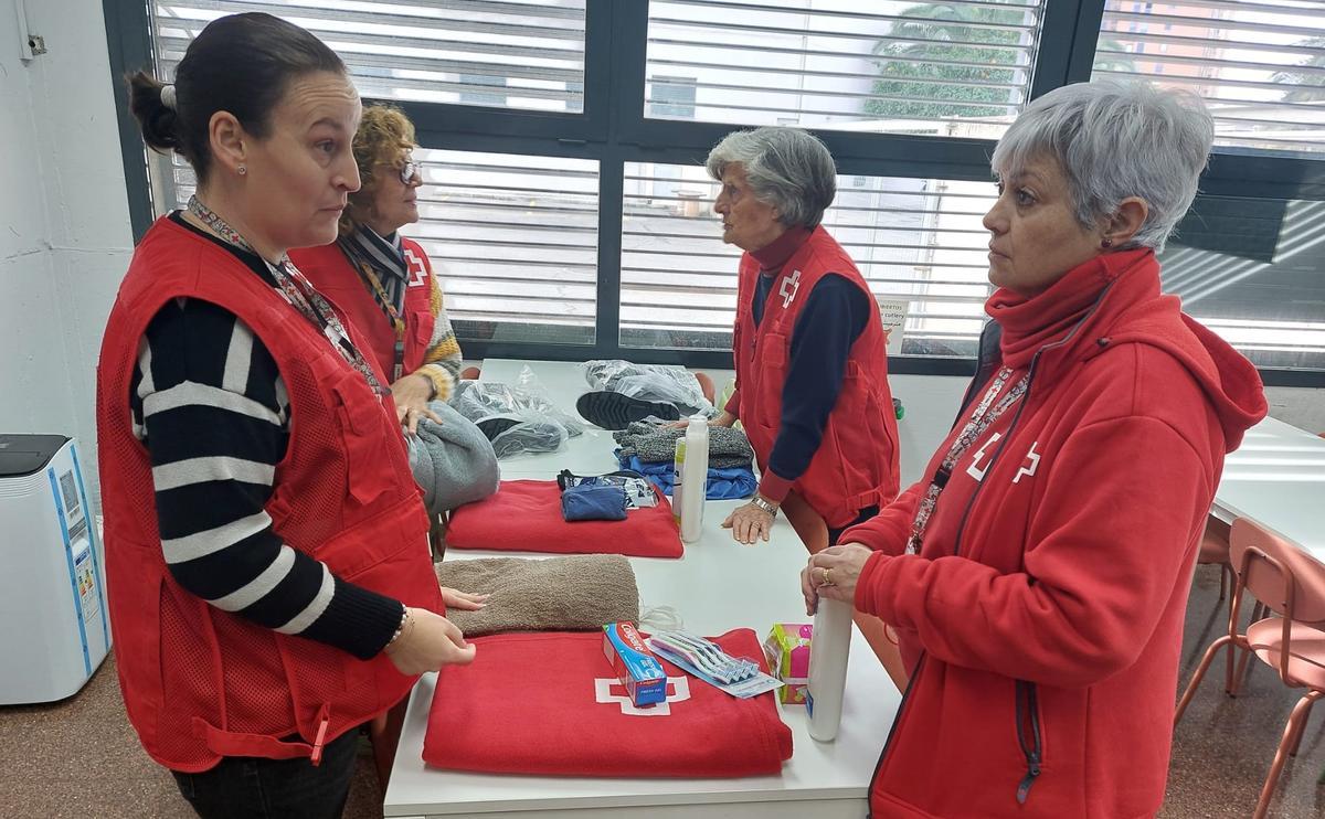 Miembros de la Cruz Roja, con los lotes de higiene y abrigo