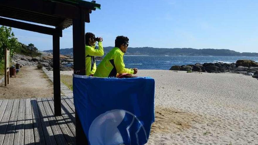 Socorristas en la playa de Lagos, con la bandera azul. // G.Núñez