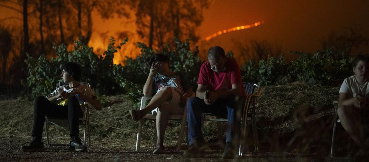 Una familia, desolada por el avance del incendio en Valdeorras, la noche del viernes al sábado.