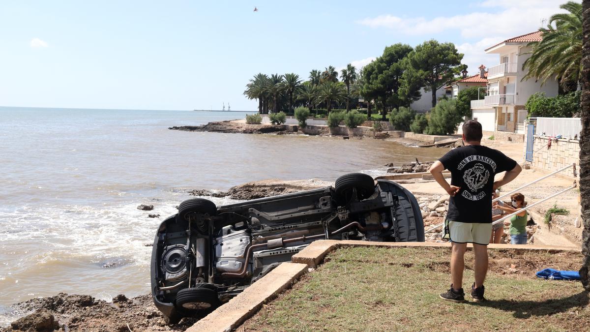 Un home mira els cotxes del càmping Alfacs que van acabar al mar