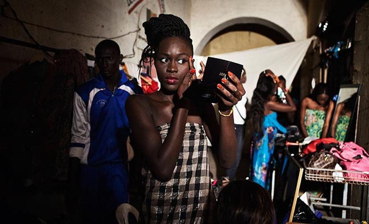 Una model senegalesa es maquilla al camerino abans d’una desfilada aquest dilluns a l’illa de Goree, davant la costa de Dakar, la capital senegalesa.
