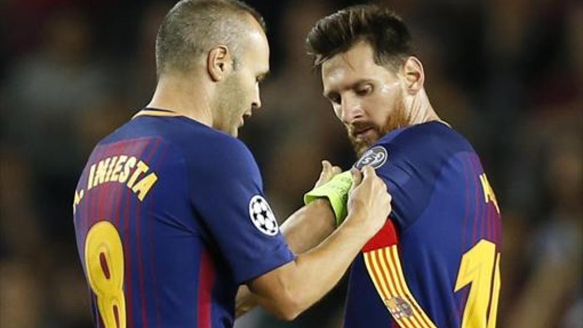 Iniesta pone el brazal de capitán a Messi.