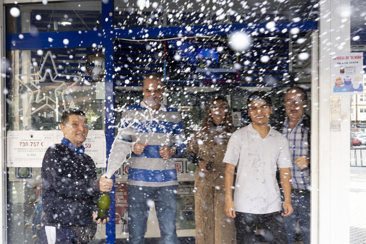 Unos afortunados agraciados con el premio en una administración de Lotería,