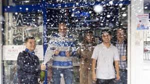 Unos afortunados agraciados con el premio en una administración de Lotería,