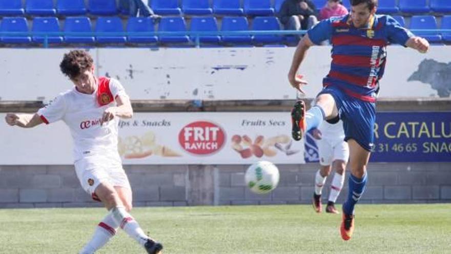 Manel prova un xut davant l&#039;oposició d&#039;un jugador del Mallorca B durant el partit de diumenge.